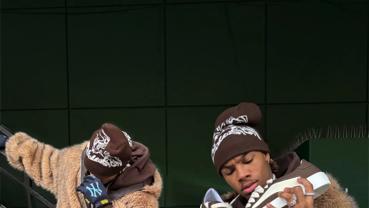 Numeris, two models in fur jackets and brown beanies holding trainers against a green staircase