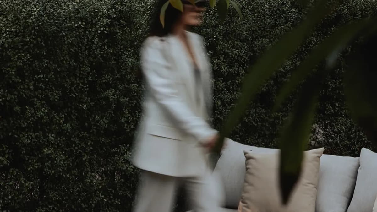 MacArthur Place, blurred figure in a white suit walking past a fire pit and lounge sofa