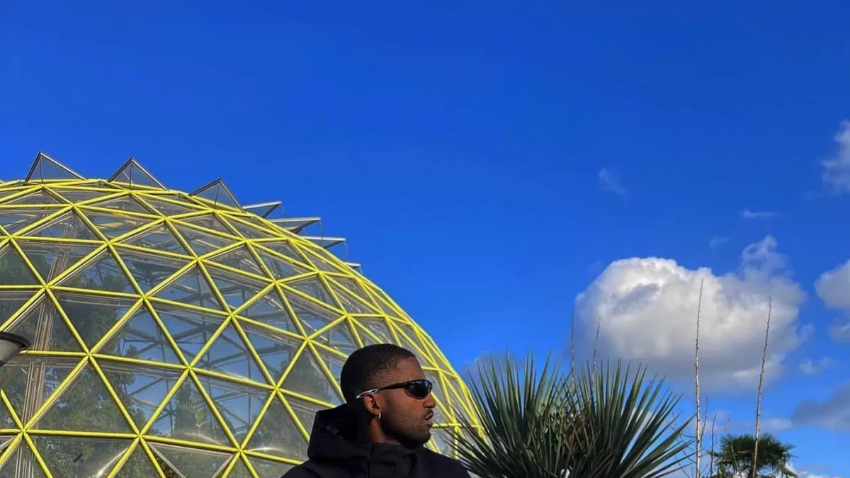 Jack Wolfskin, Pierre Laurent in a black jacket and sunglasses crouching by a glass dome