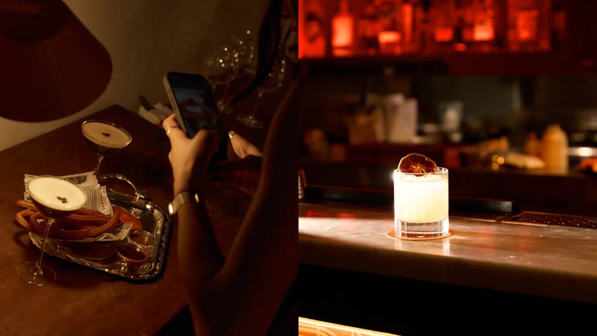 Person photographs espresso martinis and churros on a phone; a cocktail with dried citrus sits on a dimly lit bar