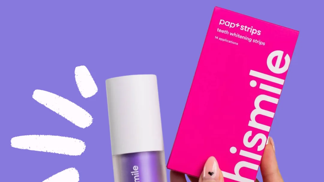 Manicured hand holds pink HiSmile "pap+strips" teeth whitening box beside a purple bottle on a lilac background