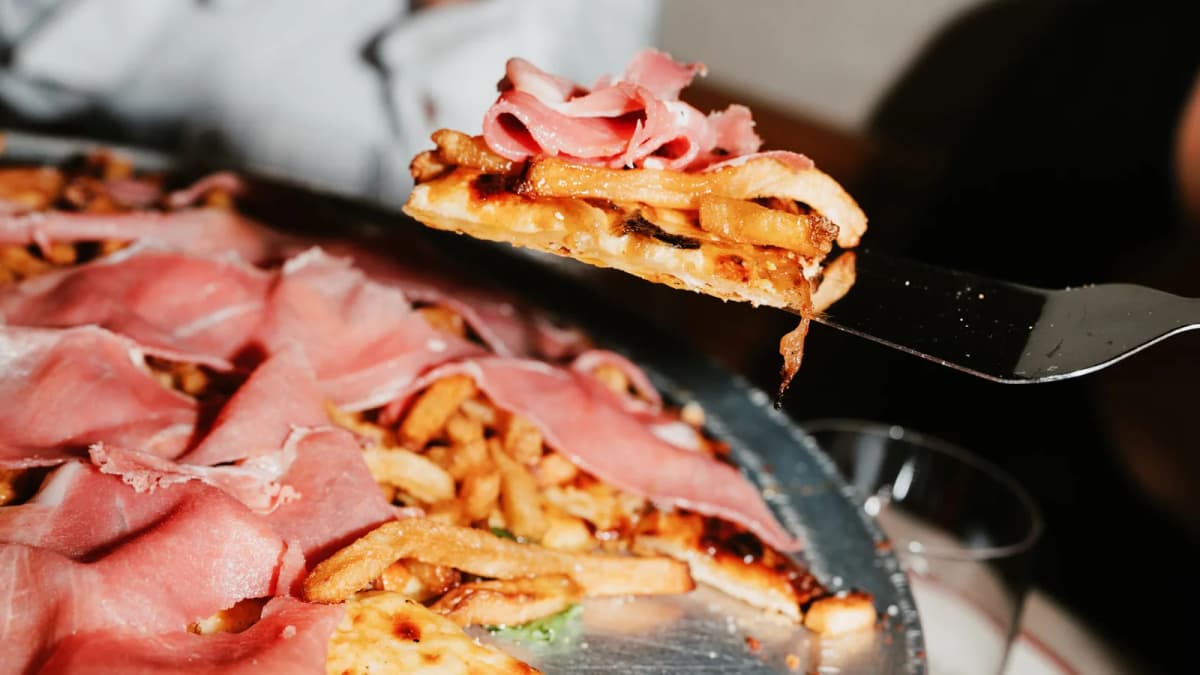 A slice of Emmett's on Grove's Hot Goat pizza on a silver metal server.