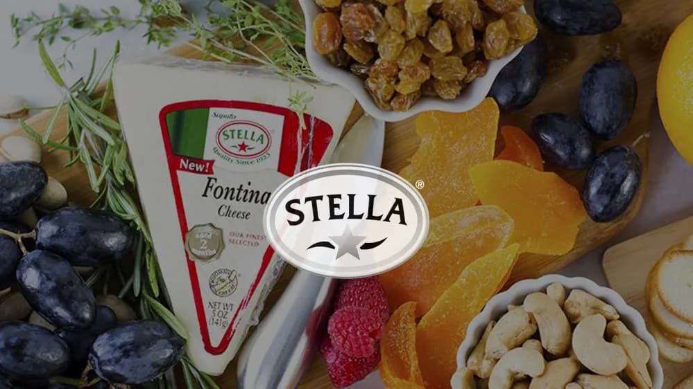 Stella "Fontina Cheese" wedge with grapes, dried mango, raisins, cashews and raspberries; Stella logo centered